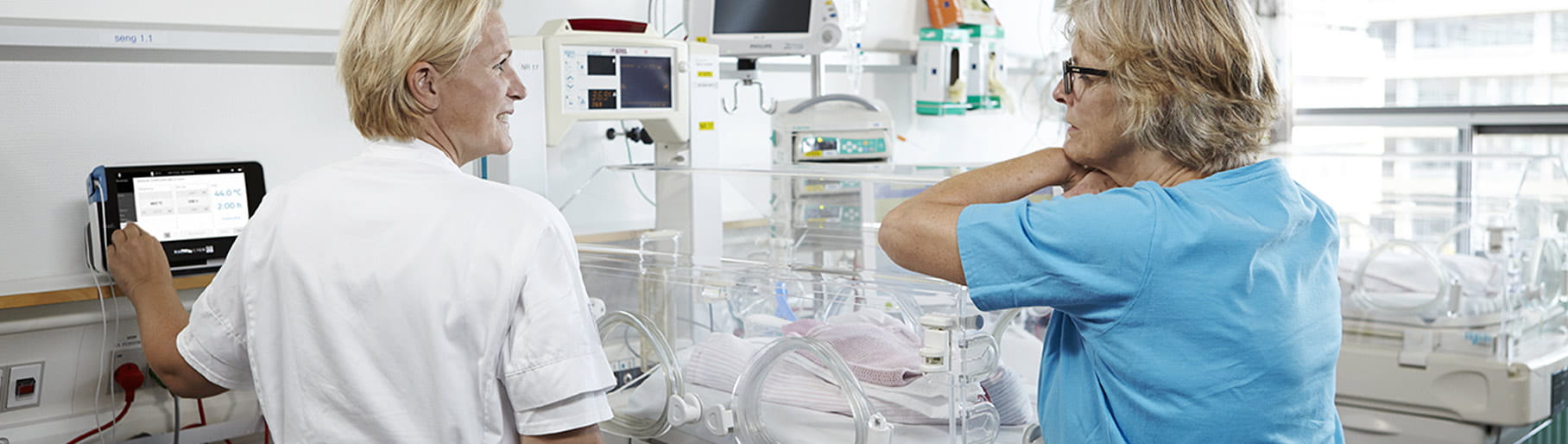 病院環境 - NICU の看護師2名、ラジオメーターの経皮モニターを使用